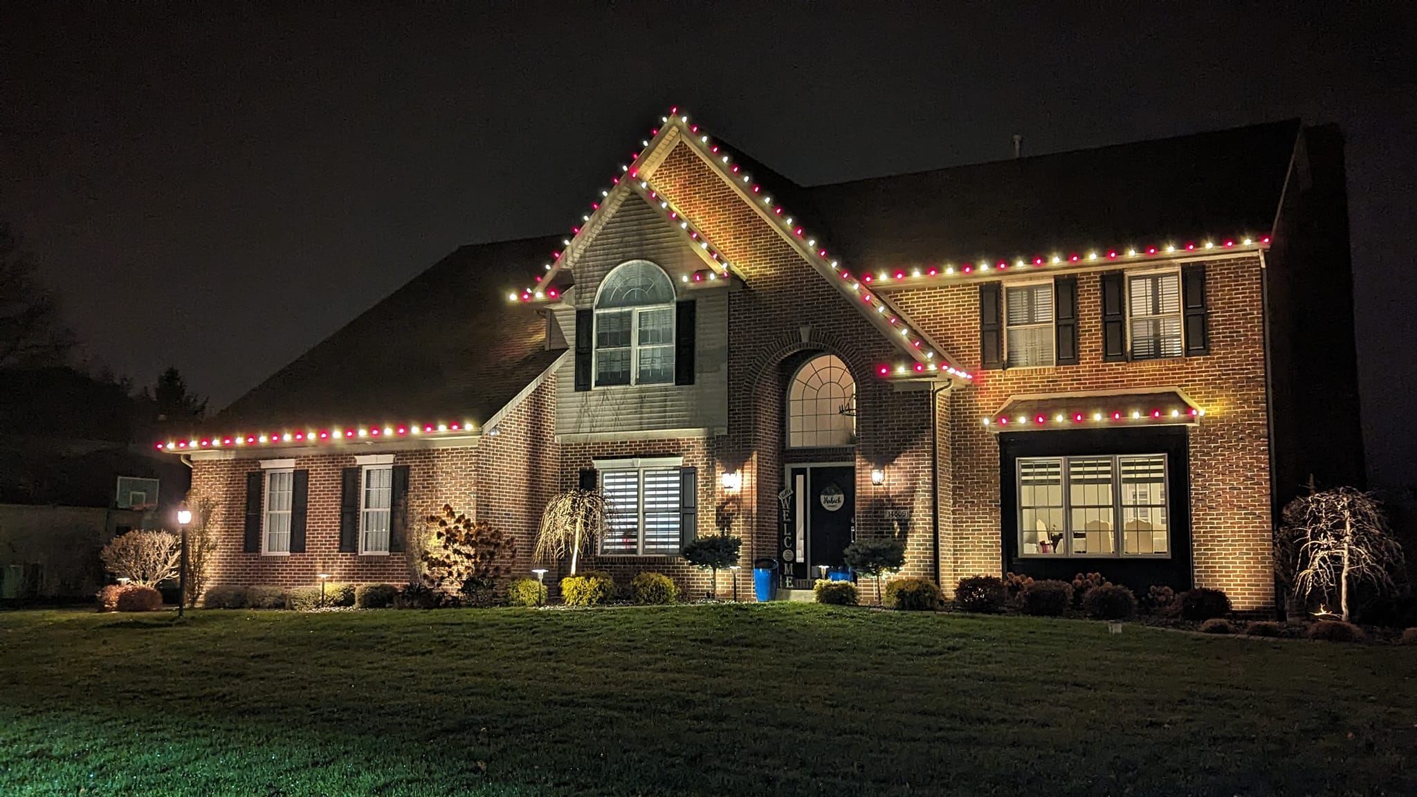 tall brick home with christmas lights along roofline
